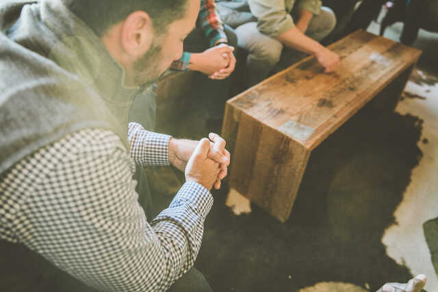 men praying together during community group