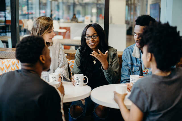 Group of college students having an animated discussion over coffee
