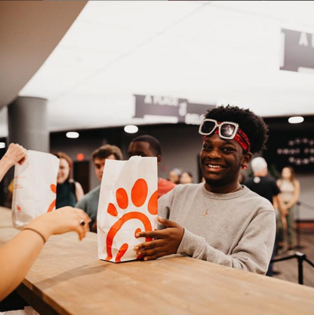 happy college student graciously accepts free chick fil a dinner