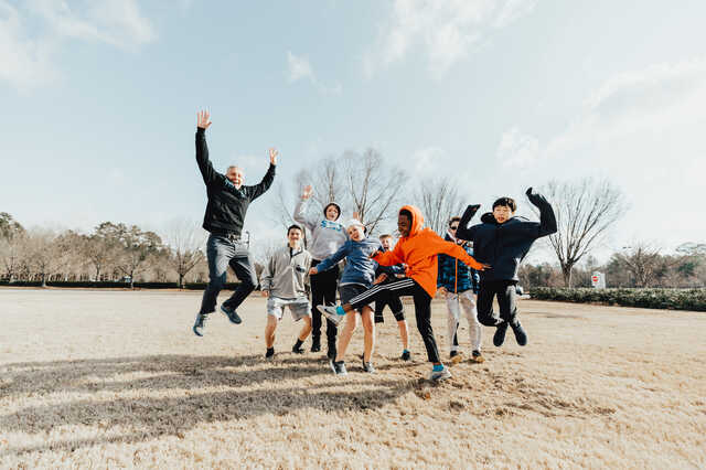 Transit small group jumping for joy in field