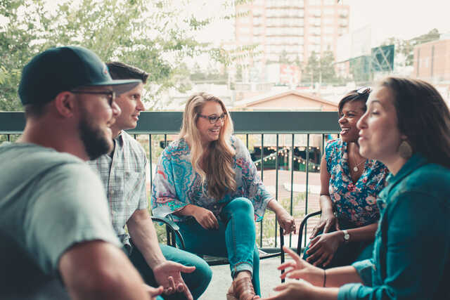 group of interracial singles talking on a patio