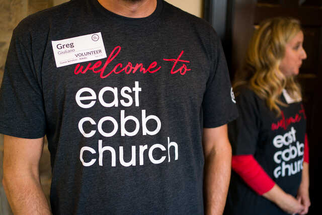 man at entrance to east cobb church wearing a welcome shirt
