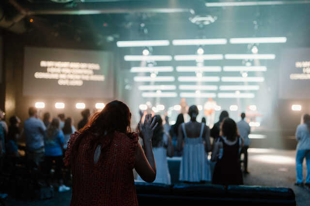 young adult woman with hands up in worship at npya