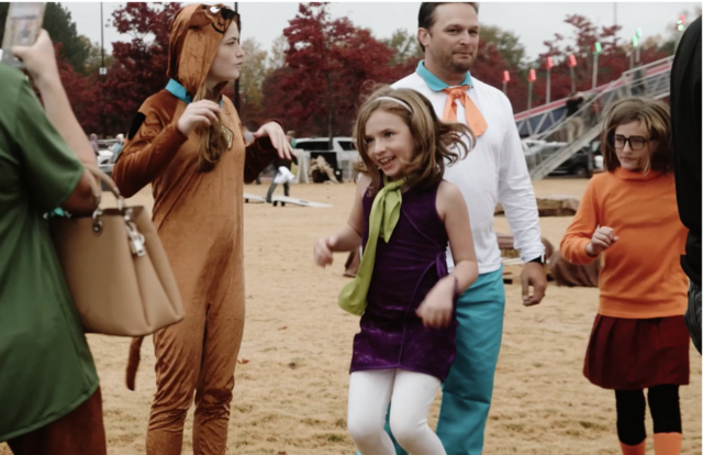 family dressed as scooby doo characters dancing at fall fest